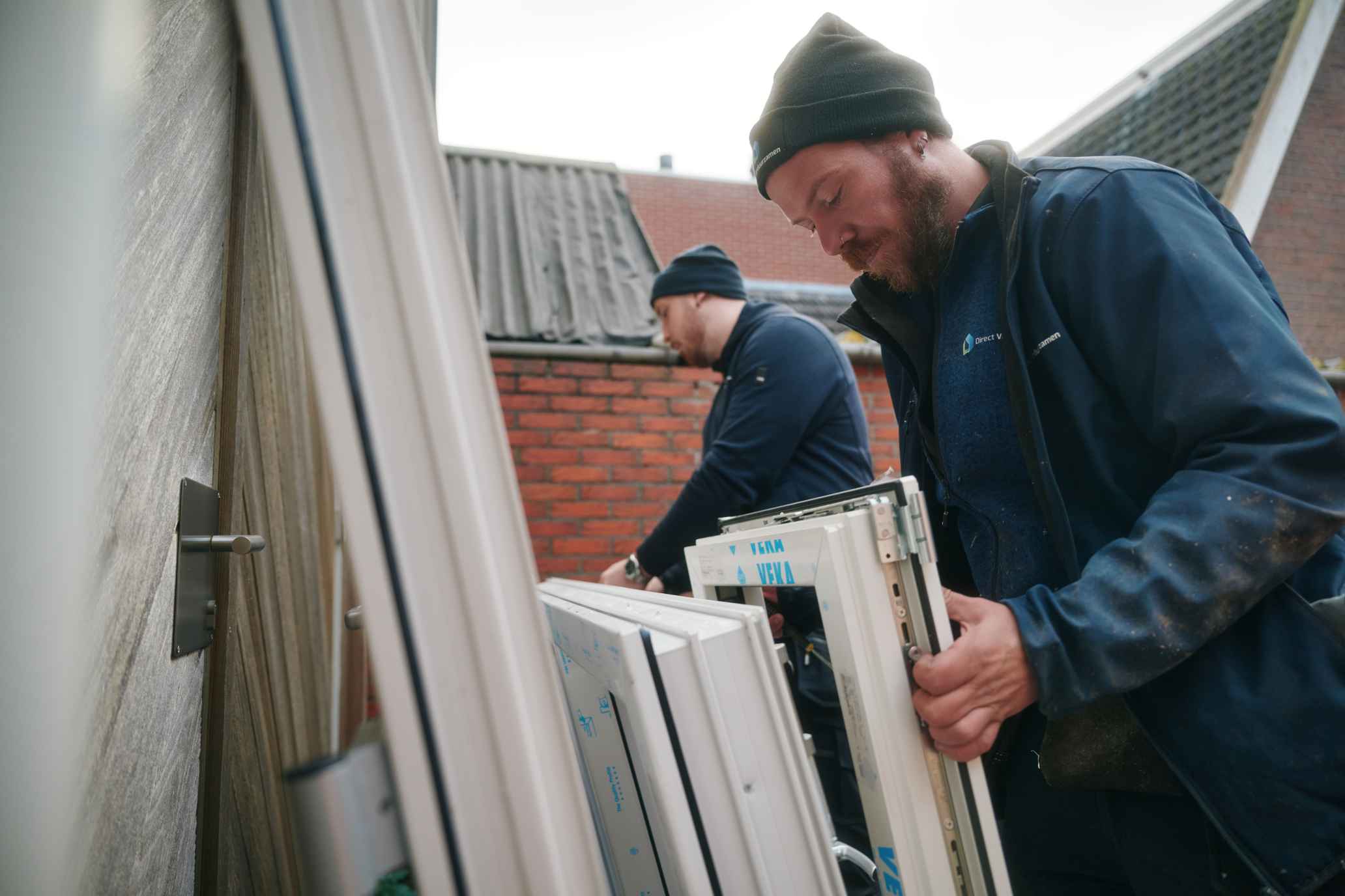 Monteur van Direct Verduurzamen met een wit kunststof kozijnprofiel