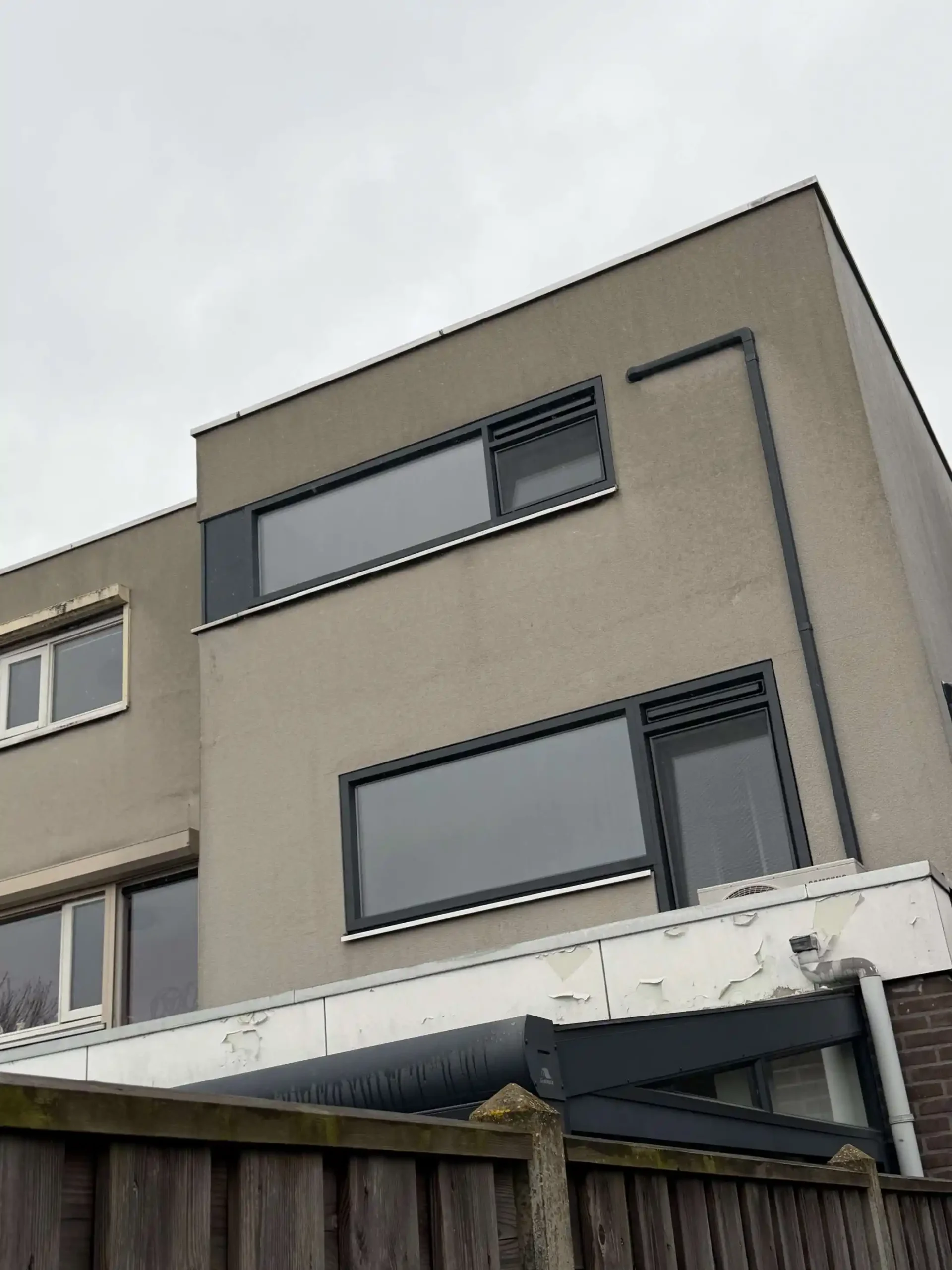 Modern woonblok met meerdere bouwlagen en antraciet kunststof kozijnen