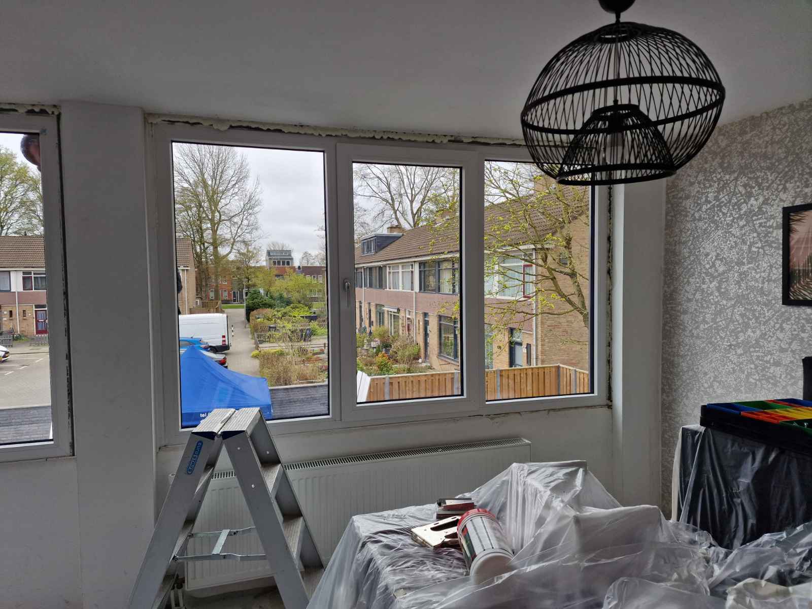 Witte kunststof kozijnen aan de binnenkant van een woonkamer, tijdens de oplevering