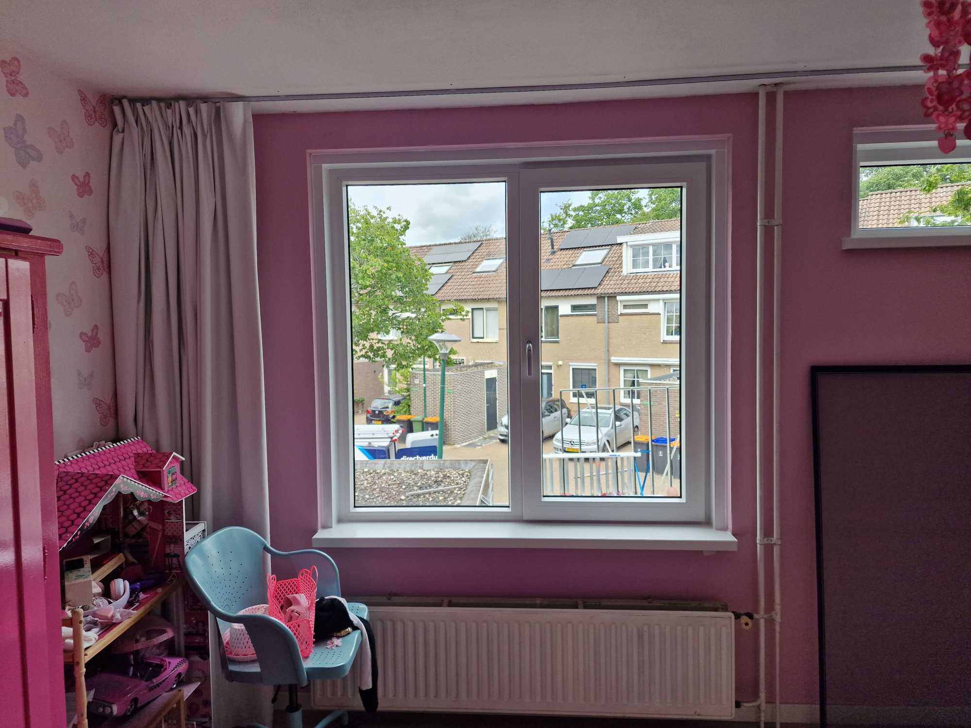 Kinderkamer met een nieuw wit kunststof draaikiepraam boven de radiator