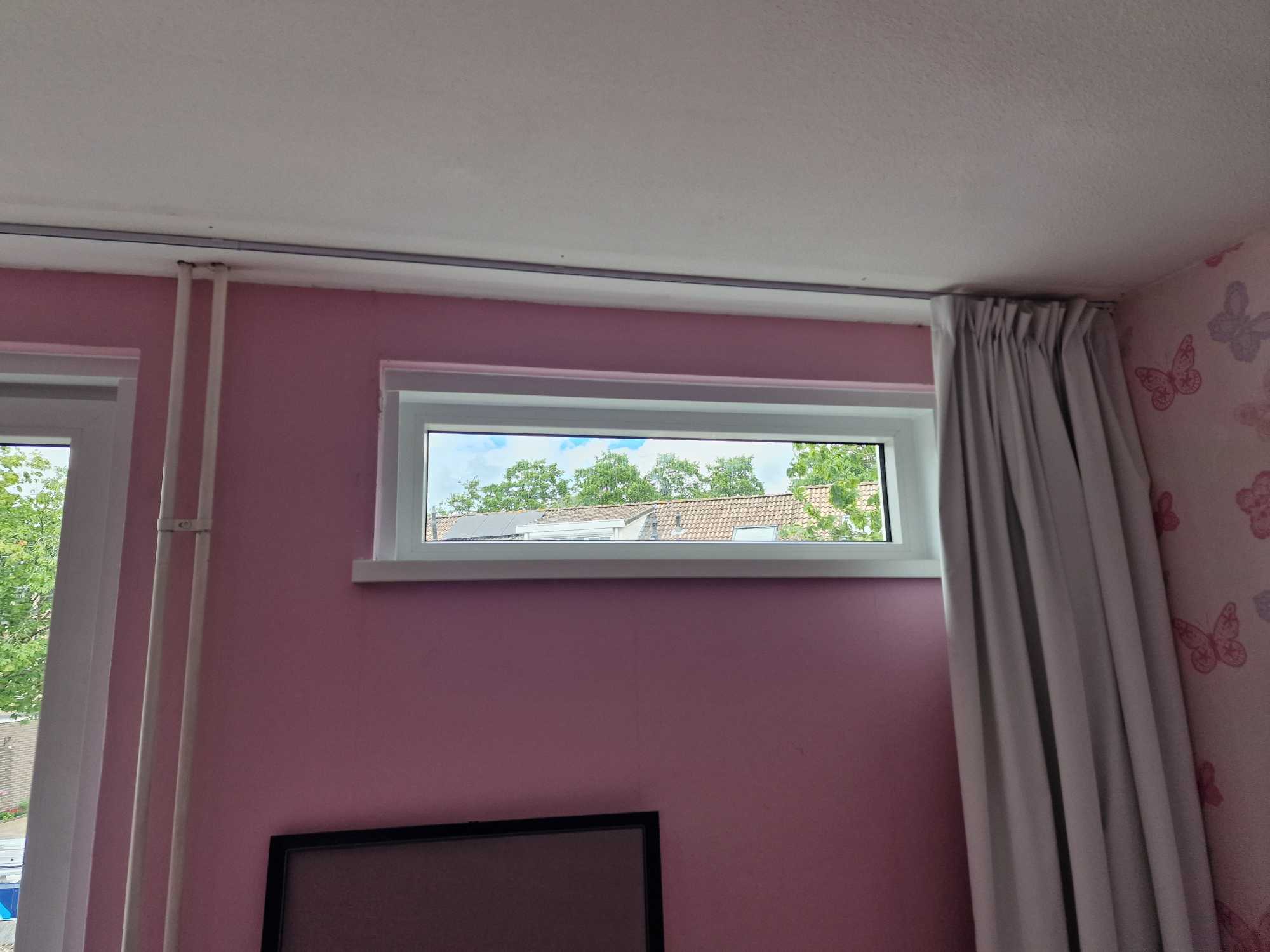 Hoog geplaatst wit bovenlicht in een kinderkamer, buiten bereik van kinderen
